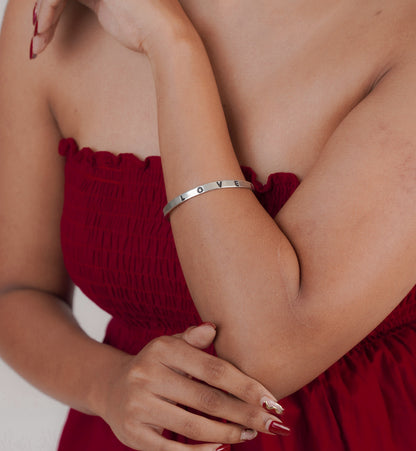 Woman wearing simple silver love letter bracelet – Luxteno Sri LankaClose-up of silver love letter charm bracelet on wrist – Sri Lanka jewellery
