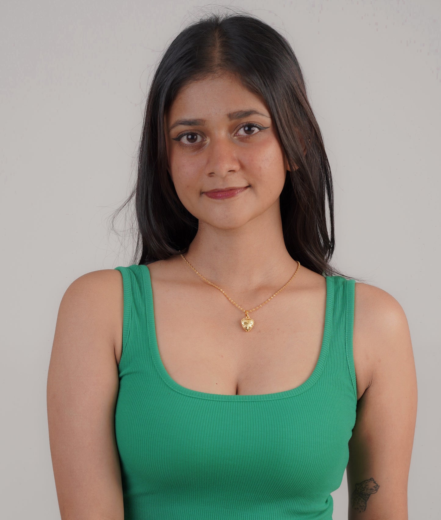 Woman wearing water wave heart necklace with green top – Luxteno Sri Lanka